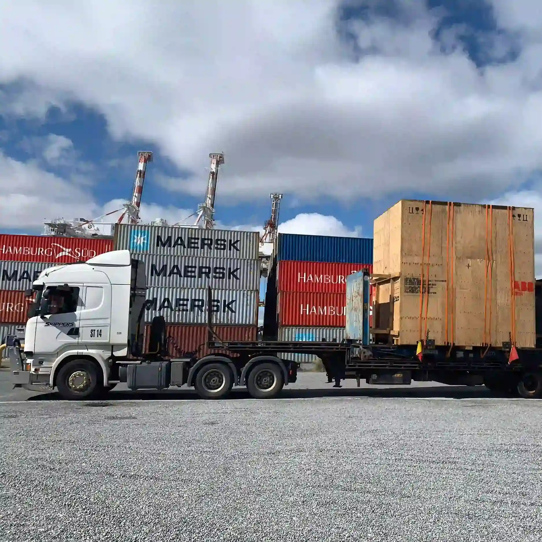 a picture of a truck at the port in fremantle picking up a container
